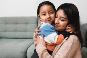 Building relationships, Happy Latin American mother and son hugging each other at home - Family love concept - Focus on child face